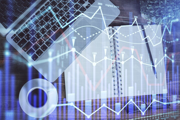 Financial market graph and top view computer on the desktop background. Double exposure. Investment concept.