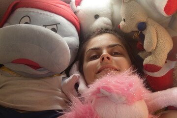 Close-up of a young girl's face surrounded by honey bunnies and toys