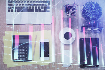 Double exposure of forex chart hologram over desktop with phone. Top view. Mobile trade platform...