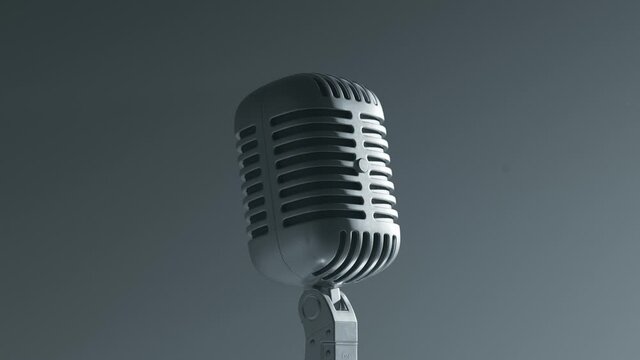 A desaturated vintage microphone on the stage. Closeup. Grey background. Old mic