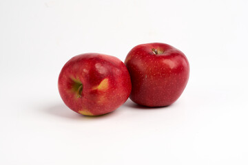 Two red shiny apples over white background
