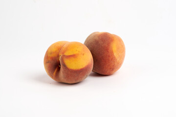 two ripe peaches on a white background