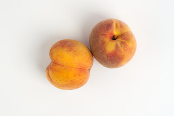 two ripe peaches on a white background