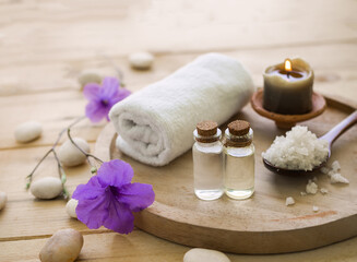 Obraz na płótnie Canvas coconut oil and massage oil with spa salt, candle, towel on wooden background.