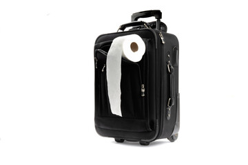 a roll of toilet paper in the cover of a black carry on suitcase isolated on white
