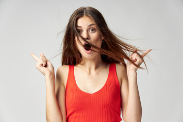 Obraz premium Woman with open mouth shows fingers to the side Red T-shirt Coffee Space