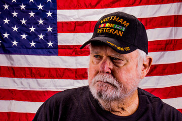 Vietnam Veteran Looking Away Suspiciously With American Flag Background
