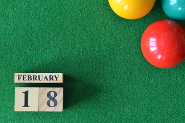 February 18, number cube with balls on snooker table, sport background.