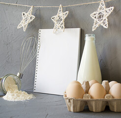 milk, eggs, flour on the table. Notebook with a place for text. cooking christmas breakfast