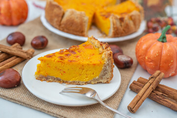 slice of pumpkin pie on plate with pumpkins