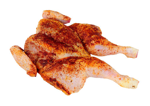Raw spatchcock chicken with piri piri seasoning isolated on a white background