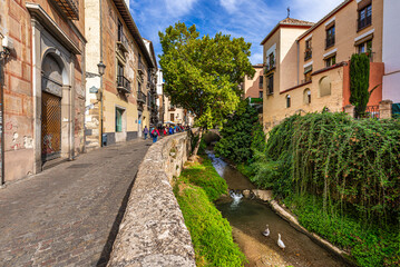 Granada, Spain October 17th, 2019. View on Carrera del Darro Street, the street that runs along the Darro River, and on the ancient buildings of the historic city center.