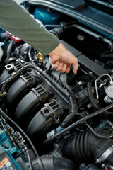 Obraz na płótnie Canvas Close up of man hand checking the engine of a broken car