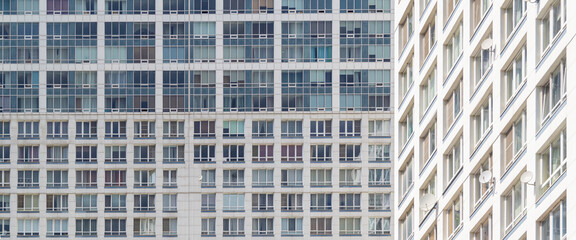 Building facades with many glazed balconies and windows. Abstract geometrical view of part of new...