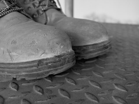 Isolated pair of safety shoe or steel-toe boots used for construction purpose.