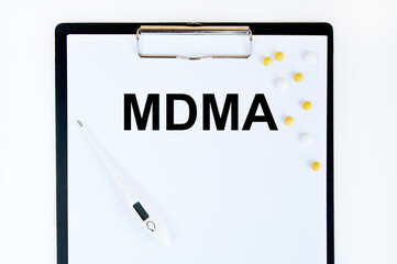 Text MDMA on a white background. Nearby are various medicines. Medical concept.