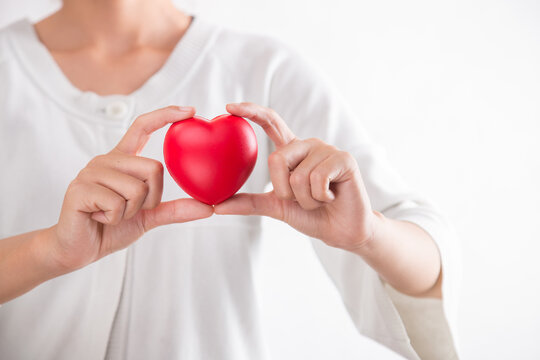 Woman holding red heart symbol of World heart day. White background isolated.