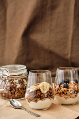 Close up of delicious layered dessert in glass jar, Homemade yogurt with granola and berries, Granola baked with nuts and honey