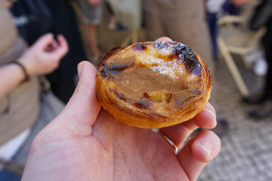 Hand holding pastel de nata, a Portuguese pastry