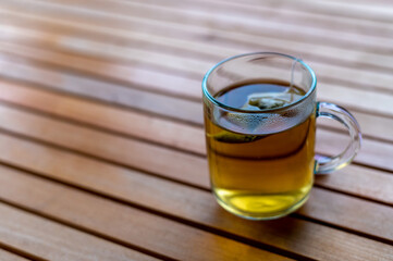 Glass cup of tea on wooden table