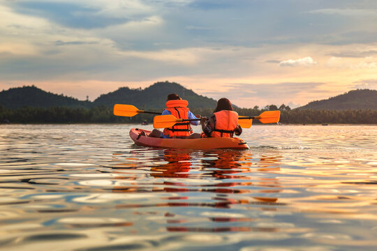 Tourist paddling the kayak on the sea among the beautiful scenery during sunset at koh pitak , chumphon province in Thailand. This is very popular for photographers and tourists.