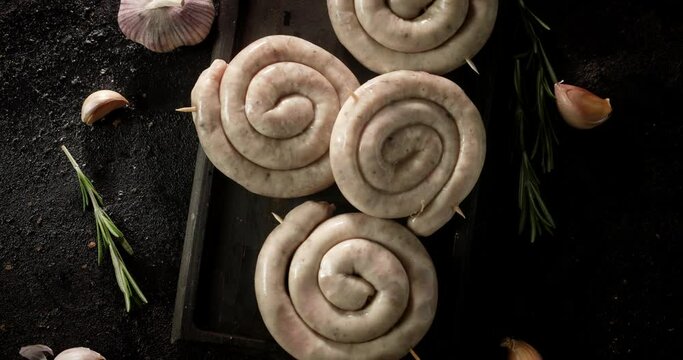 Raw sausages with garlic and rosemary rotate. 