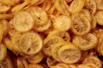 Dried orange in sugar cut into round slices by weight on the counter at the market. Dried fruits and Oriental sweets.
