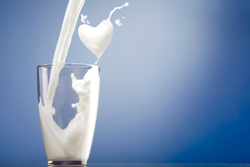 Milk pouring into glass and heart shape from milk