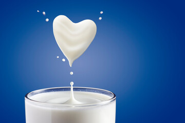 Milk pouring into glass and heart shape from milk