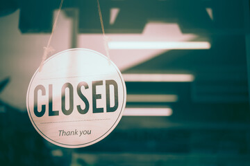 Text on white sign board  “Closed” infront of the mirror’s  shop . This shop was dark and  closed beacuse of the bankrupcy.