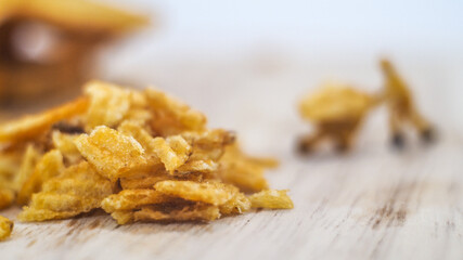 Miniature people, Workers work on  production potato chips on white background (food concept)