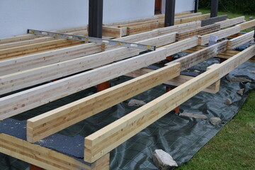Backyard terrace construction - wooden frame for patio deck with foundation made of pipes filled with concrete. DIY concept.
