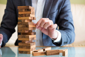 Selective focus at wood brick. Business people dress in formal suit taking risk and make decision to play the game. Insurance or financial risk management concept.