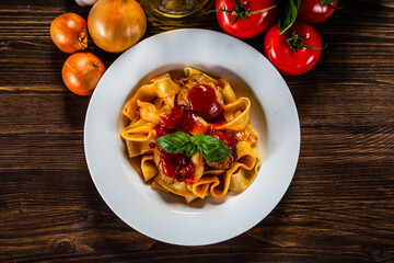 Pasta with meatballs in tomato sauce on wooden background

