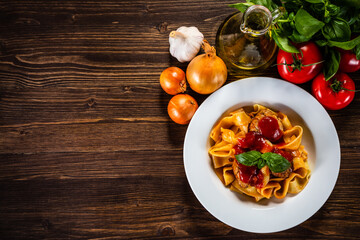 Pasta with meatballs in tomato sauce on wooden background
