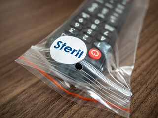 Obraz premium TV remote control in steril bag ready to use in hotel room. COVID-19 protection concept.