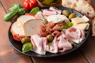 Piatto di prosciutto cotto, salame,guanciale, gorgonzola e grana, antipasti italiani 