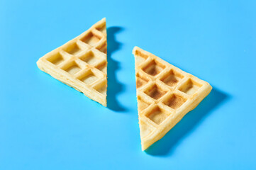 Cutted vanilla belgian waffles on blue background