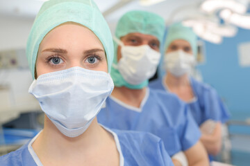 Fototapeta na wymiar three surgeons at work operating in surgical theatre