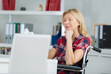 beautiful middle-aged woman in wheelchair reading at home