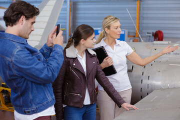 member of ground crew is showing airplane to students
