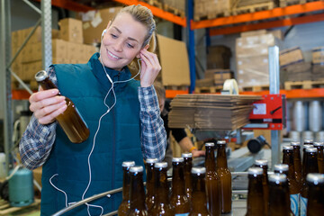 worker putting her headset while looking at a bottle