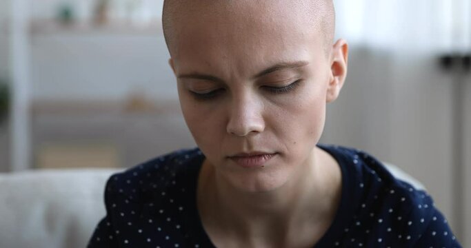 Close up face bald woman sit indoor look at camera, lost of hope feels despair. Malignant inoperable tumor, ineffective treatment, addicted female, HIV AIDS incurable disease person portrait concept