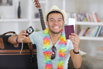 happy young vietnamese man with digital camera and passport
