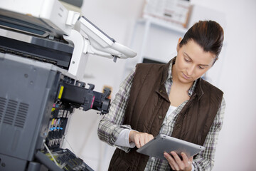 female photocopier technician holding digital tablet