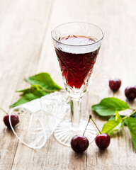 Cherry liqueur in a glass and fresh fruits