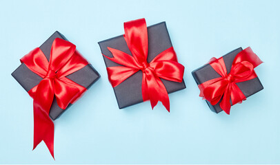 Black friday sale flat lay with gift box and ribbon, copy space, christmas and holidays concept on blue background