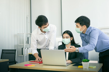 Obraz premium Young business human resources working with face mask in the office during COVID-19 pandemic.