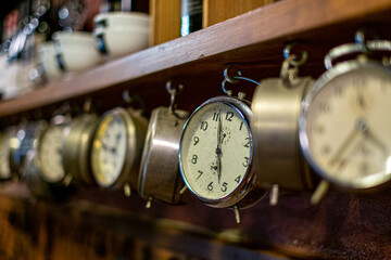 Old alarm clocks hanging from a shelf inside an old tavern