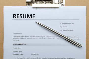Closeup and top view of resume form on the clipboard and silver pen